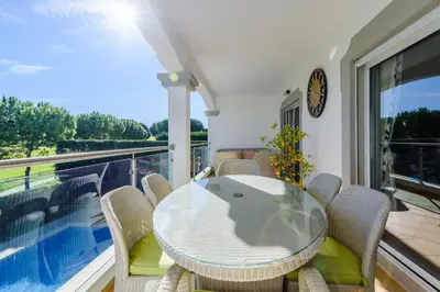 a dining room with a glass table and chairs on a balcony at The White House in Lagos