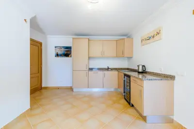 a kitchen with wooden cabinets and a counter top at The White House in Lagos