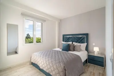 a bedroom with a large bed and two windows at Lux House - free park- WiFi - Sea View in Funchal