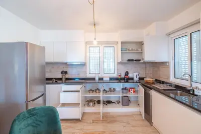 a kitchen with white cabinets and a refrigerator at Lux House - free park- WiFi - Sea View in Funchal
