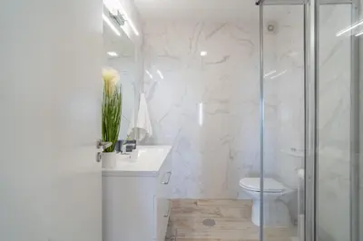 a white bathroom with a shower and a toilet at Lux House - free park- WiFi - Sea View in Funchal
