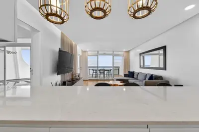 a bedroom with a large white bed and wooden floors at Sunset Atlantic Gardens Apartments 408 in Funchal