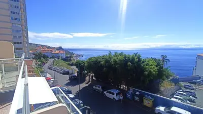 a view of the ocean from a balcony of a building at Sunny Pearl Apartment in Caniço