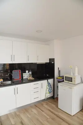 a kitchen with white cabinets and a microwave at Sunny Pearl Apartment in Caniço