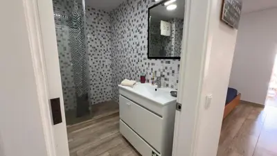 a bathroom with a white sink and a mirror at Sunny Pearl Apartment in Caniço