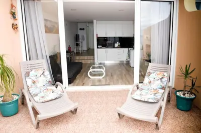 two white chairs sitting in front of a mirror at Sunny Pearl Apartment in Caniço