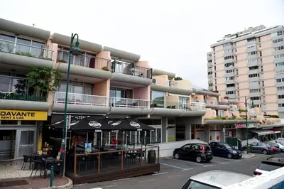 a large apartment building with cars parked in a parking lot at Sunny Pearl Apartment in Caniço
