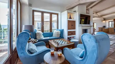 a living room with blue chairs and a table with chess at Luxury Villa by the Sea with Ocean Views in Luz