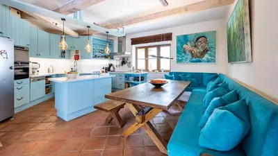 a kitchen with a blue couch and a wooden table at Luxury Villa by the Sea with Ocean Views in Luz