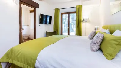 a bedroom with a large white bed with green sheets at Luxury Villa by the Sea with Ocean Views in Luz