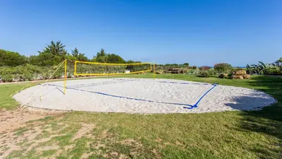 a volleyball court with a net on the grass at Luxury Villa by the Sea with Ocean Views in Luz