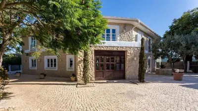 a large house with a garage and a driveway at Luxury Villa by the Sea with Ocean Views in Luz