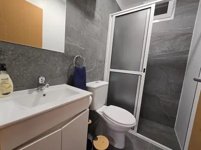 a bathroom with a toilet and a sink and a shower at Autonomia House I in Câmara de Lobos
