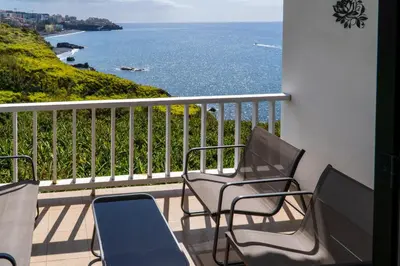 a balcony with chairs and a view of the ocean at Villa Irene in Funchal
