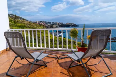 two chairs sitting on a balcony overlooking the ocean at Villa Irene in Funchal