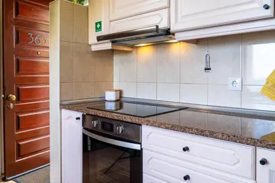 a kitchen with white cabinets and a stove top oven at Villa Irene in Funchal