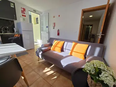 a living room with a gray couch with orange pillows at Autonomia House II in Câmara de Lobos