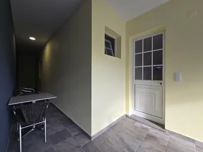 a room with a table and a door and a chair at Autonomia House II in Câmara de Lobos