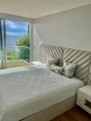 a bedroom with a large bed with a large window at Vila Da Luz Calheta in Estreito da Calheta