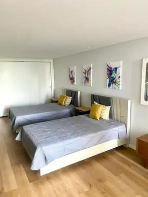two beds in a room with paintings on the wall at Vila Da Luz Calheta in Estreito da Calheta