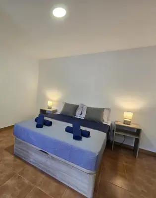 a bedroom with a bed with two blue pillows on it at Autonomia House III in Câmara de Lobos