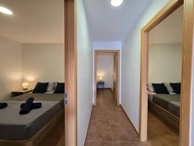 a bedroom with two beds and a mirror at Autonomia House IV in Câmara de Lobos