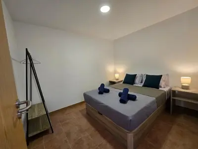 a bedroom with a bed with blue pillows on it at Autonomia House IV in Câmara de Lobos