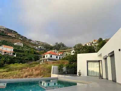 a villa with a swimming pool and a house at Sun Temple by Madeira Holiday Rentals in Ribeira Brava