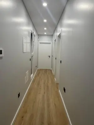 a hallway with white walls and wooden floors and doors at Sun Temple by Madeira Holiday Rentals in Ribeira Brava