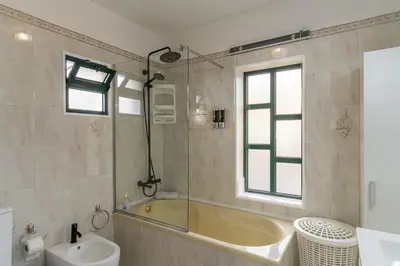 a bathroom with a tub and a toilet and a sink at GuestReady - Restful Getaway in Madeira in Estreito da Calheta