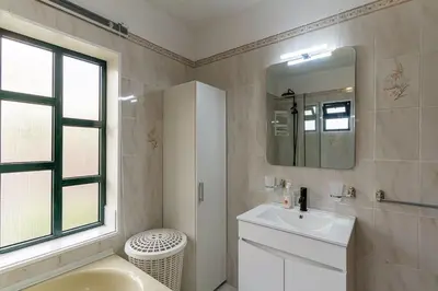 a white bathroom with a sink and a mirror at GuestReady - Restful Getaway in Madeira in Estreito da Calheta