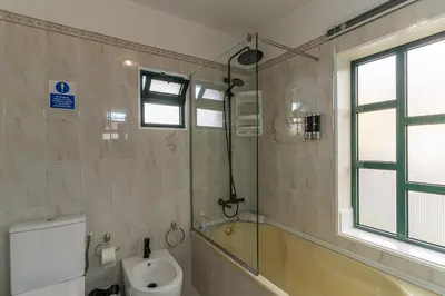 a bathroom with a tub and a toilet and a window at GuestReady - Restful Getaway in Madeira in Estreito da Calheta