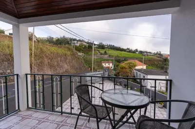 a patio with a table and chairs on a balcony at GuestReady - Restful Getaway in Madeira in Estreito da Calheta