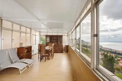 a large room with windows and a table and chairs at Carros De Cesto Do Monte in Funchal