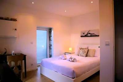 a bedroom with a bed with pink walls at Casa Tio Albino I, By OP in Ponta Delgada
