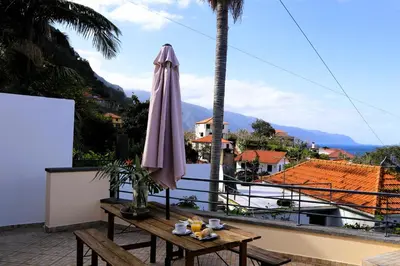 a patio with an umbrella and a table at Casa Tio Albino I, By OP in Ponta Delgada