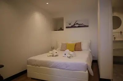 a bedroom with a white bed with shoes on it at Casa do Tio Albino II, By OP in Ponta Delgada
