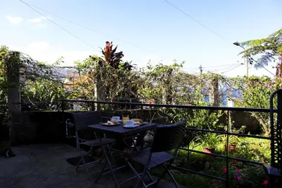 a patio with a table and chairs on a balcony at Casa do Tio Albino II, By OP in Ponta Delgada