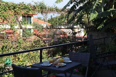 a table with cups and drinks on a balcony at Casa do Tio Albino II, By OP in Ponta Delgada