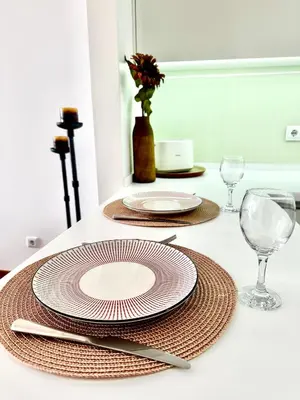 a table with two plates and glasses on a table at Reis Magos Ocean View in Caniço