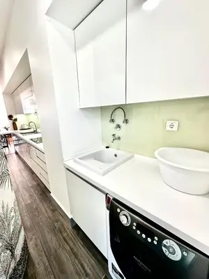 a kitchen with white cabinets and a sink at Reis Magos Ocean View in Caniço