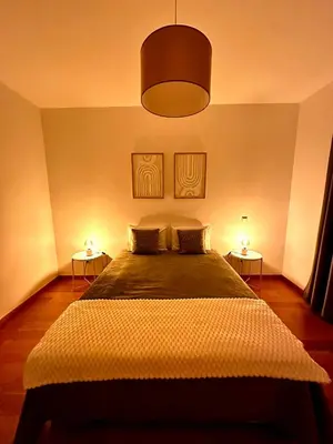 a bedroom with a large bed with two lamps at Reis Magos Ocean View in Caniço
