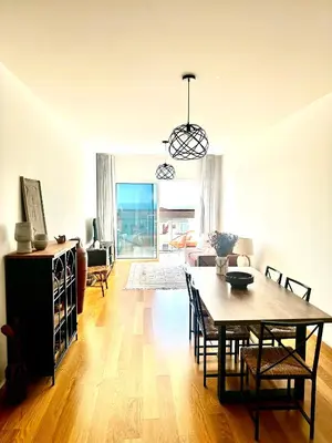 a dining room and living room with a table and chairs at Reis Magos Ocean View in Caniço