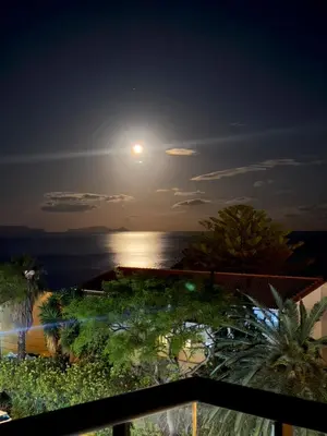 a full moon rising over the ocean at night at Reis Magos Ocean View in Caniço