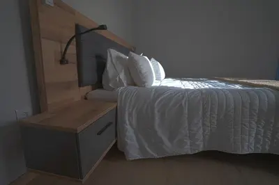 a bedroom with a bed with a wooden head board at Moonfall House in Arco da Calheta