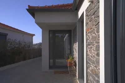 a door to a house with a stone wall at Moonfall House in Arco da Calheta