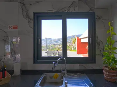 a kitchen sink with a window in a kitchen at Moonfall House in Arco da Calheta