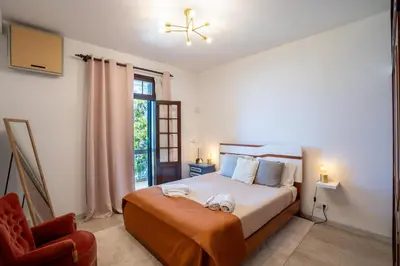 a bedroom with a bed and a chair and a window at Villa Ocean Bay Funchal By Empório in Funchal