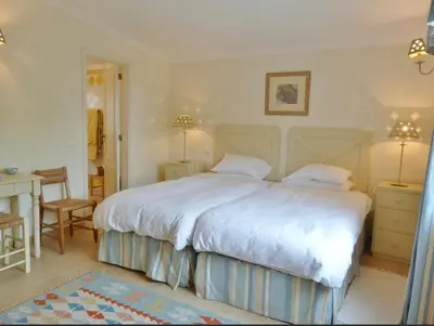a bedroom with a large white bed and a desk at Casa AncoraDouro in Lagos