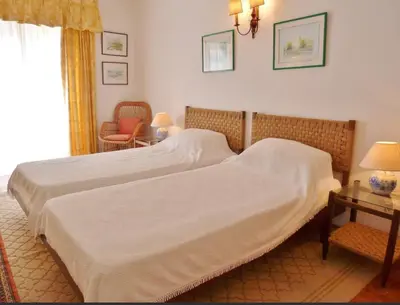 a bedroom with two beds and a chair and a window at Casa AncoraDouro in Lagos